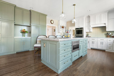 Inspiration for a large traditional kitchen in Cincinnati with a submerged sink, shaker cabinets, green cabinets, engineered stone countertops, green splashback, ceramic splashback, stainless steel appliances, dark hardwood flooring, an island, brown floors and multicoloured worktops.
