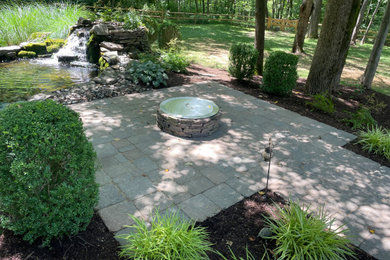 Inspiration for a mid-sized mediterranean shade backyard stone formal garden in New York with a fire pit for summer.