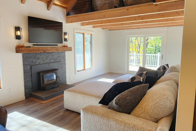 Example of a mid-sized mountain style loft-style vinyl floor living room design in Wilmington with a wood stove and a stone fireplace