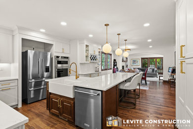 Example of a large minimalist medium tone wood floor, brown floor and wood ceiling eat-in kitchen design in Other with a drop-in sink, white cabinets, marble countertops, white backsplash, marble backsplash, stainless steel appliances, an island and white countertops
