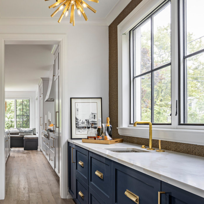 The custom Butler's Panty showcases high gloss navy cabinetry, which conceals both a Scotsman Ice Maker and Sub Zero Refrigerator Drawers. The custom mosaic backsplash is created from gold harlequin i