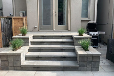 Mid-sized minimalist stamped concrete back porch idea in Toronto