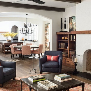 Imagen de salón para visitas cerrado, mediterráneo, de tamaño medio, sin televisor, con paredes blancas, suelo de madera oscura, chimenea tradicional, marco de chimenea de ladrillo y suelo marrón