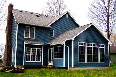 Example of a mid-sized classic blue two-story vinyl gable roof design in New York
