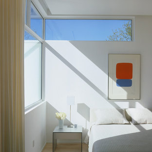 Diseño de dormitorio minimalista con paredes blancas y suelo de madera clara