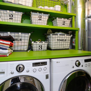 ニューヨークのエクレクティックスタイルのおしゃれなランドリールーム (オープンシェルフ、緑のキャビネット、緑の壁、左右配置の洗濯機・乾燥機、緑のキッチンカウンター) の写真