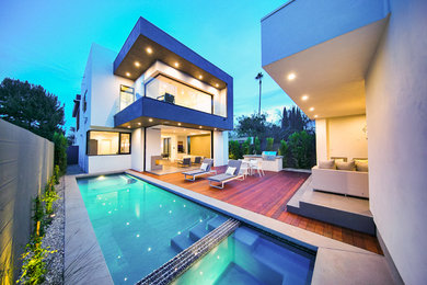 Inspiration for a mid-sized modern backyard rectangular lap pool in Los Angeles with a hot tub and concrete pavers.