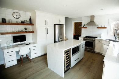 Kitchen - mid-sized transitional u-shaped medium tone wood floor and brown floor kitchen idea in Omaha with an undermount sink, shaker cabinets, white cabinets, quartzite countertops, white backsplash, ceramic backsplash, stainless steel appliances, an island and white countertops