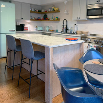 Curated Condo: Eclectic Kitchen, Light Wood Island, Veined Quartz