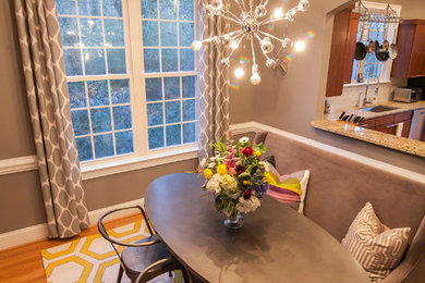 This is an example of a small eclectic separate dining room in Charlotte with grey walls and light hardwood floors.