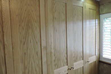 バッキンガムシャーにある広いトランジショナルスタイルのおしゃれな主寝室 (マルチカラーの壁、カーペット敷き、ベージュの床、壁紙)