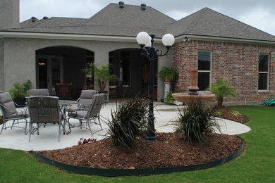 Photo of a traditional backyard patio in New Orleans with an outdoor kitchen and concrete slab.