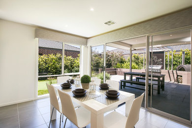 Photo of a contemporary dining room in Melbourne with white walls and ceramic floors.