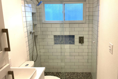 Inspiration for a mid-sized contemporary kids' white tile and ceramic tile porcelain tile, white floor and single-sink bathroom remodel in Austin with raised-panel cabinets, white cabinets, a two-piece toilet, white walls, a vessel sink, quartzite countertops, white countertops, a niche and a built-in vanity