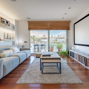 This is an example of a medium sized scandi open plan home cinema in Barcelona with white walls, medium hardwood flooring, brown floors and a projector screen.