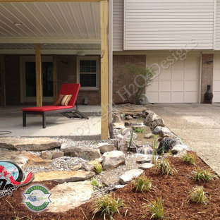 Großer Stilmix Garten hinter dem Haus mit Auffahrt, Wasserspiel und Betonplatten in Louisville
