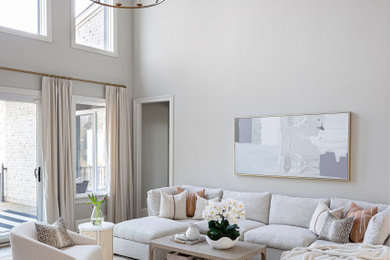 Diseño de salón abierto y abovedado grande con paredes beige y suelo de madera clara