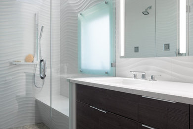 Photo of a mid-sized contemporary master bathroom in New York with flat-panel cabinets, dark wood cabinets, an alcove shower, a one-piece toilet, white tile, porcelain tile, white walls, travertine floors, an undermount sink and engineered quartz benchtops.