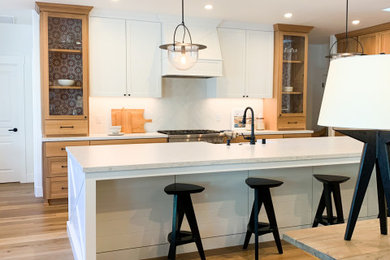 Open concept kitchen - mid-sized country l-shaped light wood floor open concept kitchen idea in Sacramento with a farmhouse sink, light wood cabinets, quartz countertops, white backsplash, cement tile backsplash, stainless steel appliances, an island and white countertops