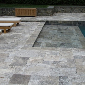 Continuance of Travertine paving onto pool sun shelf creates more visual space
