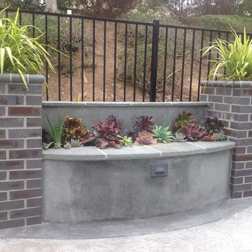 Concrete seatwall capped with flagstone and planted with succulents