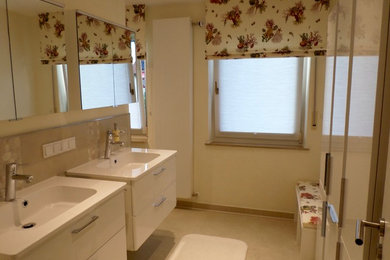 Mittelgroßes Modernes Badezimmer En Suite mit flächenbündigen Schrankfronten, weißen Schränken, bodengleicher Dusche, Wandtoilette, beigen Fliesen, Porzellanfliesen, beiger Wandfarbe, Porzellan-Bodenfliesen, Aufsatzwaschbecken, Quarzit-Waschtisch, beigem Boden und Falttür-Duschabtrennung in Sonstige