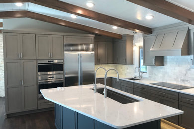 Example of a transitional shiplap ceiling eat-in kitchen design in Other with an undermount sink, flat-panel cabinets, solid surface countertops, gray backsplash, stone tile backsplash and an island