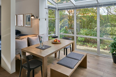 Mittelgroßes, Offenes Modernes Esszimmer ohne Kamin mit weißer Wandfarbe, braunem Holzboden und braunem Boden in Sonstige