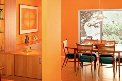 Mid-sized trendy light wood floor and brown floor kitchen/dining room combo photo in San Francisco with orange walls and no fireplace