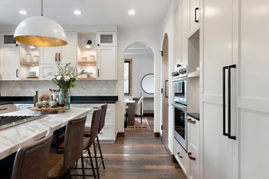 サンディエゴにあるラグジュアリーな広いトランジショナルスタイルのおしゃれなキッチン (シェーカースタイル扉のキャビネット、ベージュのキャビネット、大理石カウンター、白いキッチンパネル、無垢フローリング、茶色い床) の写真