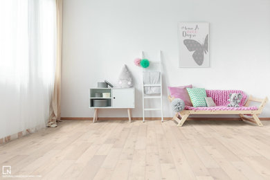 Example of a danish light wood floor and beige floor bedroom design with white walls