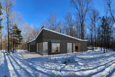 Mid-sized contemporary black one-story wood house exterior idea in New York with a shed roof, a metal roof and a black roof