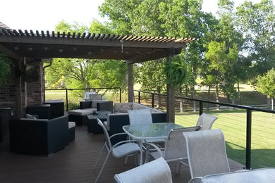 This is an example of a mid-sized contemporary backyard deck in Dallas with a roof extension.