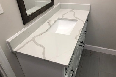 Diseño de cuarto de baño minimalista con puertas de armario blancas, aseo y ducha, lavabo bajoencimera, encimera de cuarzo compacto y encimeras blancas
