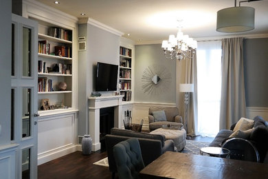 Idee per un soggiorno chic di medie dimensioni e aperto con libreria, pareti grigie, parquet scuro, camino classico, cornice del camino in legno e TV a parete