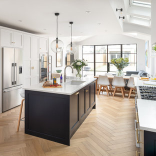 Large traditional open plan kitchen in London with shaker cabinets and an island.