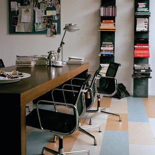 This is an example of a medium sized modern home office and library in Chicago with white walls, lino flooring, no fireplace and a freestanding desk.