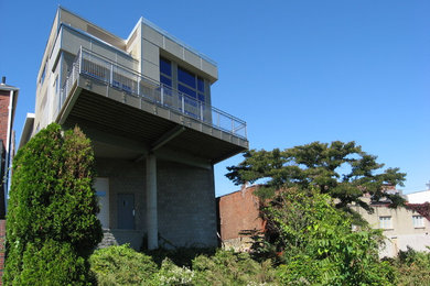Example of a trendy two-story concrete fiberboard flat roof design in Other