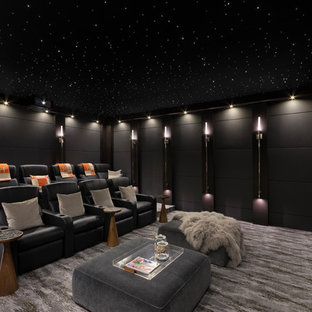 Réalisation d'une salle de cinéma design fermée avec un mur noir, moquette et un sol gris.