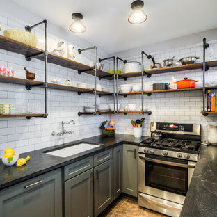 Свежая идея для дизайна: маленькая угловая кухня в стиле лофт с врезной раковиной, фасадами в стиле шейкер, серыми фасадами, столешницей из гранита, белым фартуком, фартуком из плитки кабанчик, техникой из нержавеющей стали, полом из сланца и коричневым полом без острова - отличное фото интерьера