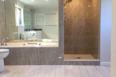 Example of a large trendy master multicolored tile and porcelain tile porcelain tile bathroom design in Other with shaker cabinets, white cabinets, a two-piece toilet, gray walls, an undermount sink and solid surface countertops