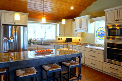 Example of a large classic l-shaped medium tone wood floor open concept kitchen design in Charlotte with an undermount sink, raised-panel cabinets, white cabinets, granite countertops, white backsplash, stainless steel appliances and an island