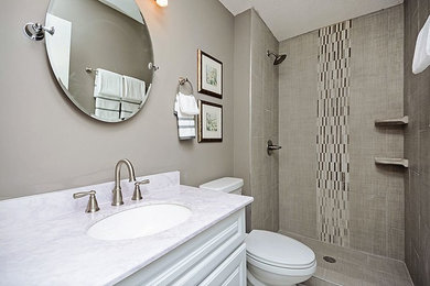 Small transitional 3/4 beige tile and mosaic tile mosaic tile floor and white floor bathroom photo in Minneapolis with raised-panel cabinets, white cabinets, a two-piece toilet, beige walls, an undermount sink, quartzite countertops and white countertops
