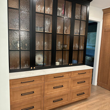 Built-in hutch featuring wood lower drawers and black-framed glass upper cabinet