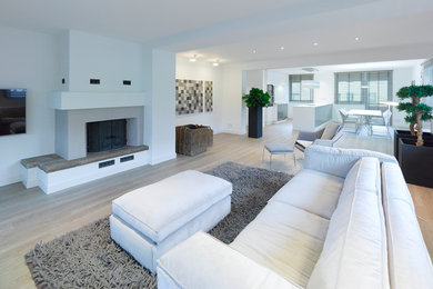 Mittelgroßes, Repräsentatives, Offenes Modernes Wohnzimmer mit weißer Wandfarbe, Vinylboden, Kamin, verputzter Kaminumrandung, beigem Boden und TV-Wand in Stuttgart