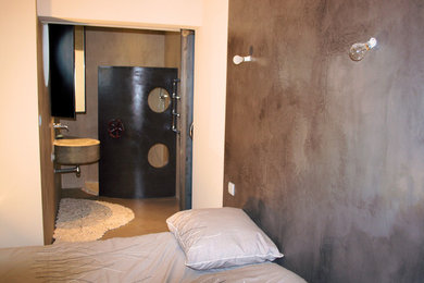Réalisation d'une salle de bain design avec une douche à l'italienne, sol en béton ciré et un lavabo suspendu.