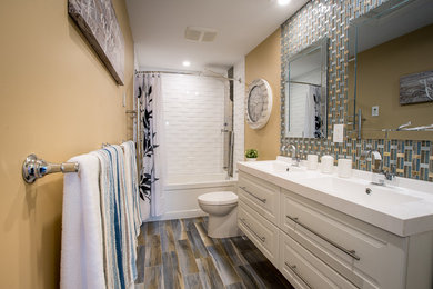Design ideas for a mid-sized beach style master bathroom in Other with raised-panel cabinets, white cabinets, an alcove tub, a shower/bathtub combo, a two-piece toilet, blue tile, ceramic tile, brown walls, ceramic floors, an integrated sink, granite benchtops, blue floor, a shower curtain and white benchtops.