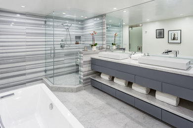 Trendy master gray tile, multicolored tile and white tile corner shower photo in Los Angeles with flat-panel cabinets, gray cabinets, a vessel sink and a hinged shower door