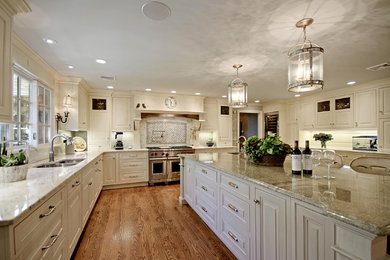 Example of a large classic medium tone wood floor eat-in kitchen design in New York with a double-bowl sink, raised-panel cabinets, white cabinets, granite countertops, stainless steel appliances and an island