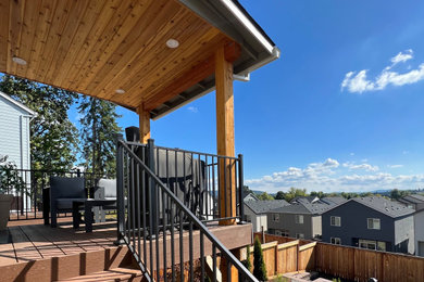 Elegant backyard second story metal railing deck photo in Portland with a roof extension